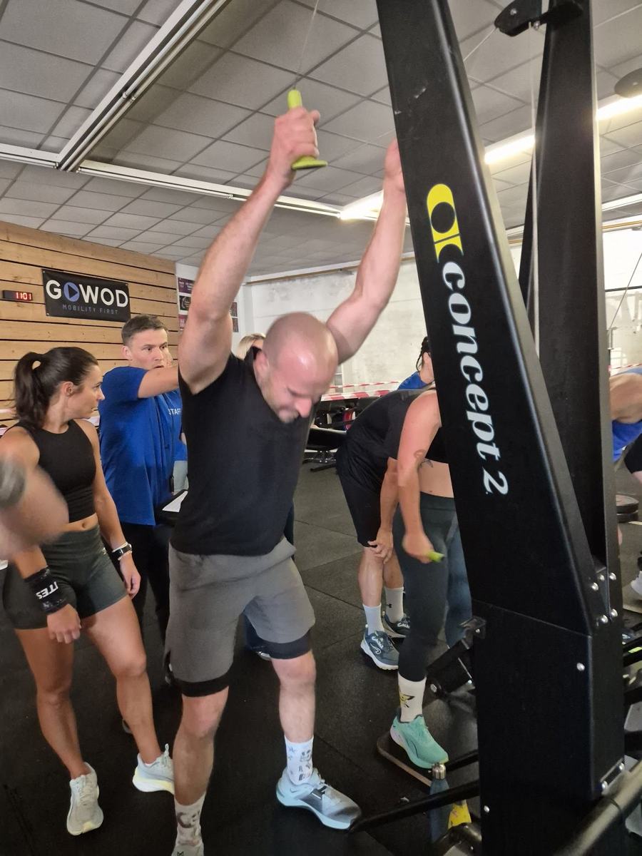 Une adhérente encouragée au rameur pendant une épreuve